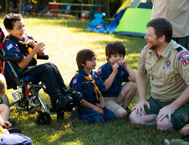Picture Scout leader talking to scouts on grass