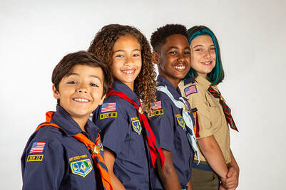 Picture Scouts line up wearing various cub scout uniforms